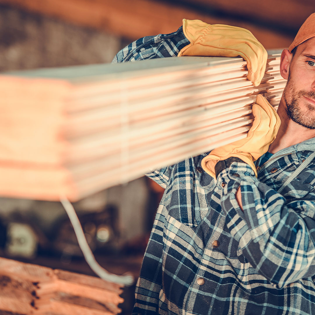 image of man carrying some lumber