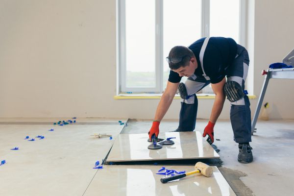 contractor working on tile floor for bathroom