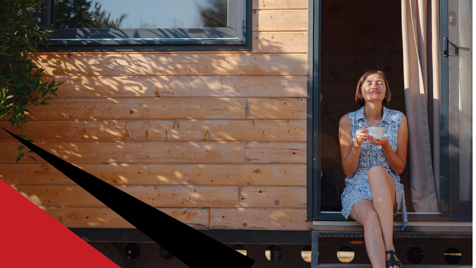woman sits on tiny home stairs in sun