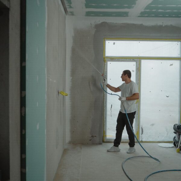 person works on construction with drywall finishing
